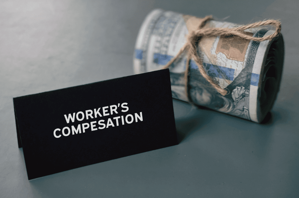 Worker's compensation card with rolled money.