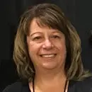 Smiling woman with shoulder-length hair against a dark background.