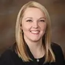 Professional portrait of a smiling woman with blonde hair.