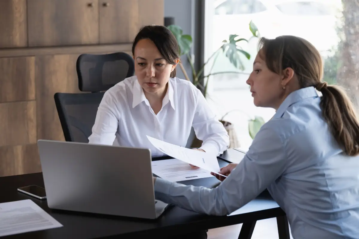 Two women collaborating at office desk.