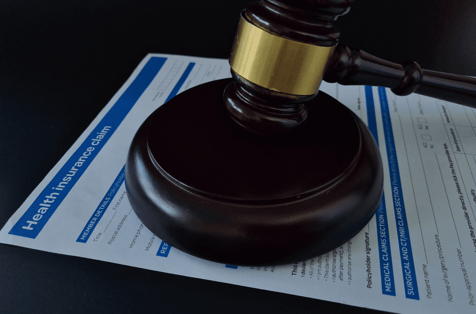 Gavel on health insurance claim document.